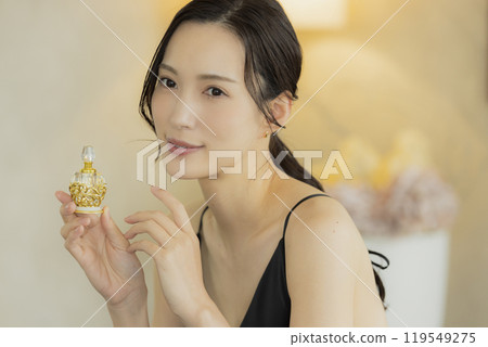 Young woman using perfume 119549275