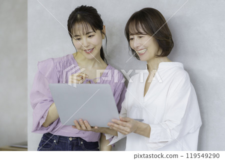 A young woman and a middle-aged woman having a conversation with a laptop 119549290