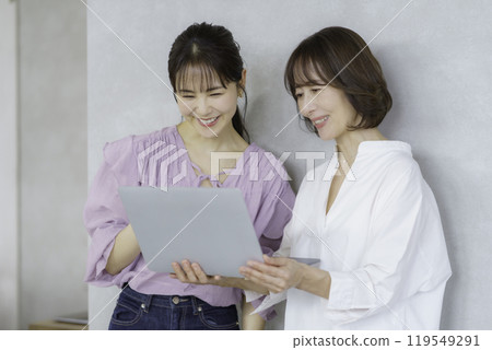 A young woman and a middle-aged woman having a conversation with a laptop 119549291