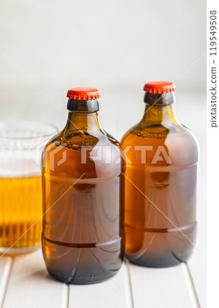Two beer bottles on white table. Two beer bottles on white table. 119549508