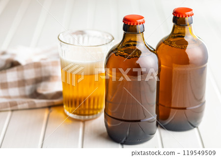 Two beer bottles on white table. Two beer bottles on white table. 119549509