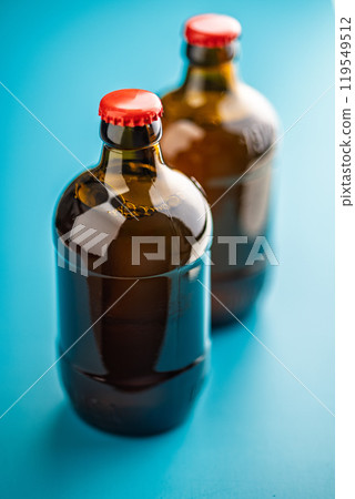 Two beer bottles on blue background. 119549512