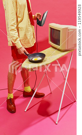 Retro-styled man with iron and vintage computer, this humorous take on office life contrasts old technology with household chores. 119549928