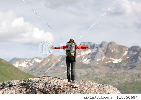 Back view of a hiker celebrating in the mountain 119550684