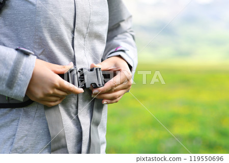 Hiker fixing backpack in the mountain Hiker fixing backpack in the mountain 119550696