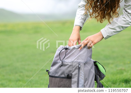 Hiker searching inside of a backpack Hiker searching inside of a backpack 119550707