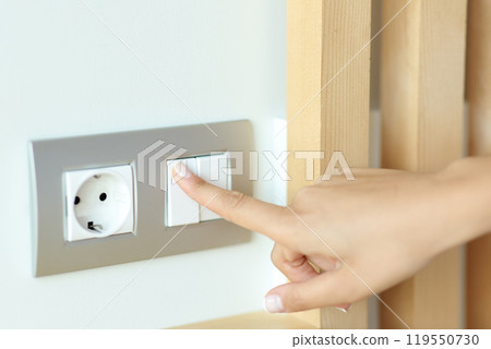 Woman hand pressing light switch Woman hand pressing light switch 119550730