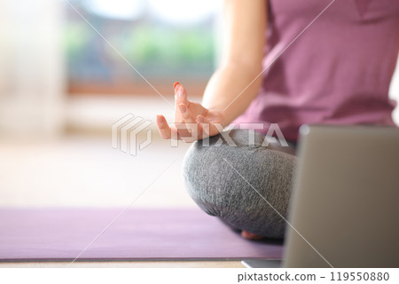 Close up of a woman doing yoga with a laptop 119550880