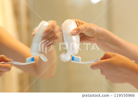 Woman hands putting toothpaste on the brush 119550966