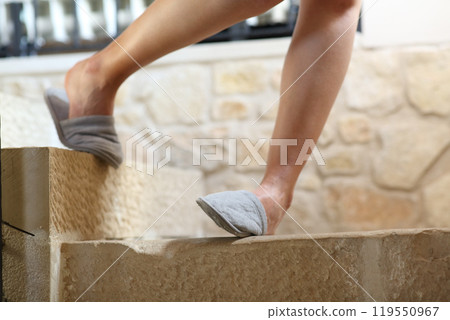 Woman legs stumbling going down the stairs 119550967