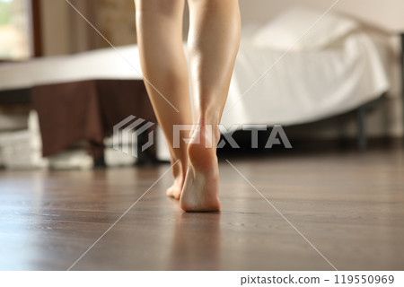 Woman legs walking on wooden floor in a bedroom 119550969
