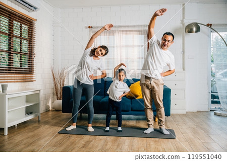 A family weekend at home becomes a harmonious and joyful experience as Asian parents and their daughter practice yoga and fitness promoting health education and togetherness. 119551040