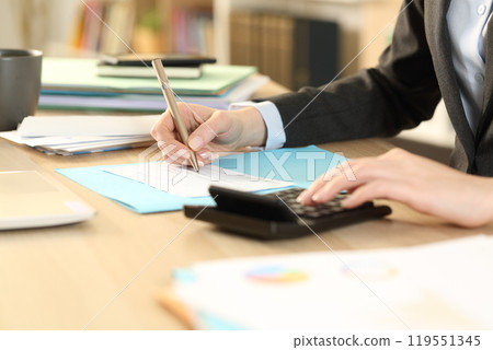 Bookkeeper hands calculating check on calculator at home 119551345