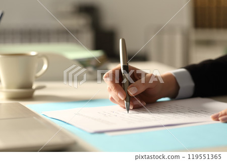 Business woman hands filling form at night in the office Business woman hands filling form at night in the office 119551365