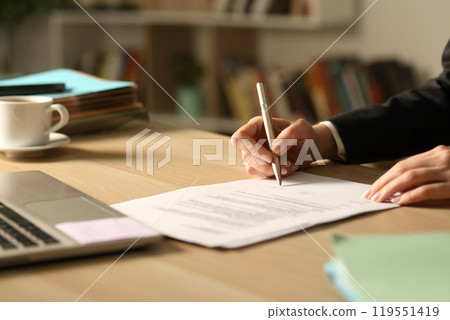 Entrepreneur hands signing contract in the night at home 119551419