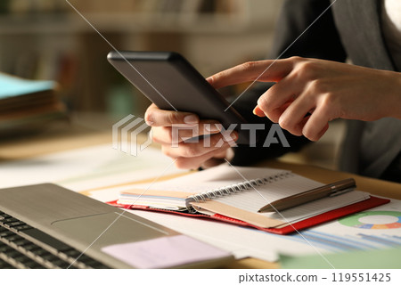 Entrepreneur hands with agenda using phone at night 119551425
