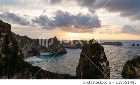 Experience the breathtaking beauty of a sunset casting vibrant hues over a rocky coastline Experience the breathtaking beauty of a sunset casting vibrant hues over a rocky coastline 119551485