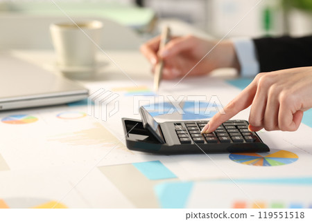 Executive hand calculating with calculator comparing graphs 119551518
