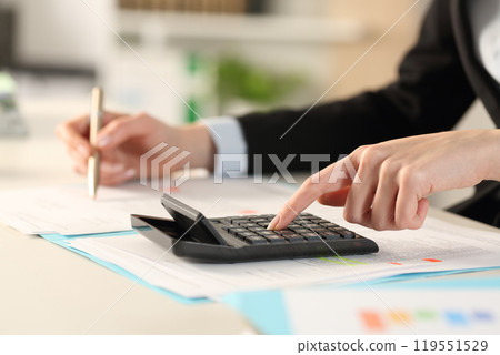 Executive hands calculating with calculator at the office 119551529