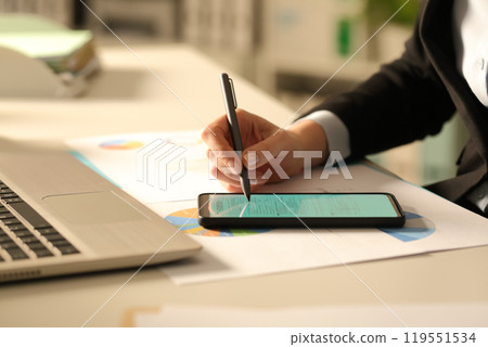 Executive hands filling form on smart phone at night 119551534