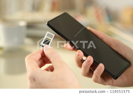 Girl hand inserting sim and sd card on smart phone 119551575