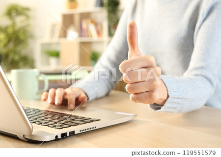 Girl hands gesturing thumbs up using laptop 119551579