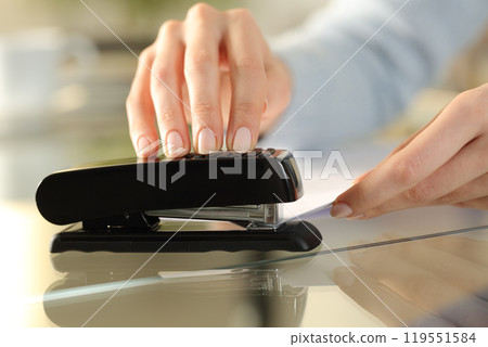 Girl hands using stapler on documents over a desk at home 119551584