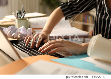 Messy entrepreneur hands working on laptop on desk at night Messy entrepreneur hands working on laptop on desk at night 119551609