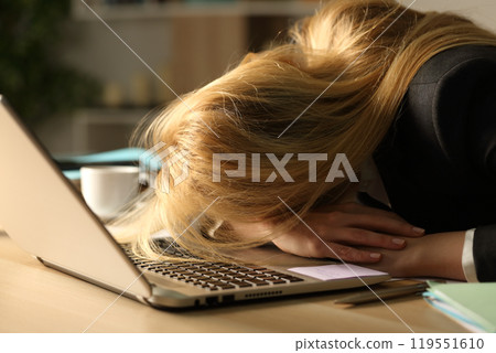 Overworked entrepreneur sleeping over desk at night 119551610