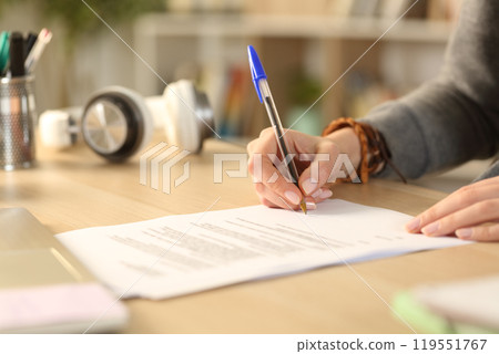 Student hands signing contract at home Student hands signing contract at home 119551767