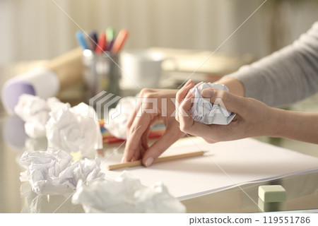 Woman crumpling piece of paper leaving pencil on desk 119551786