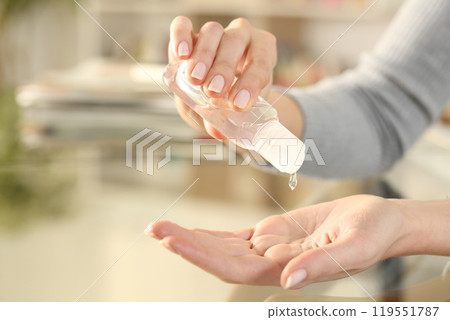 Woman disinfecting hand with sanitizer gel rub 119551787