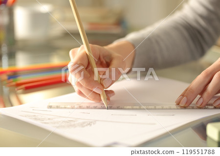 Woman drawing line with pencil and ruler on a desk at home Woman drawing line with pencil and ruler on a desk at home 119551788