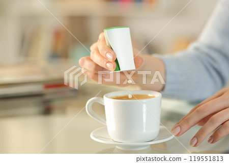 Woman hand throwing saccharin pills on coffee cup 119551813