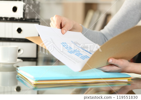 Woman hands checking documents on folders 119551830