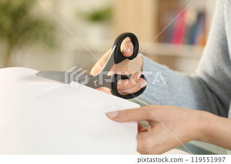 Woman hands cutting paper with scissors at home 119551997