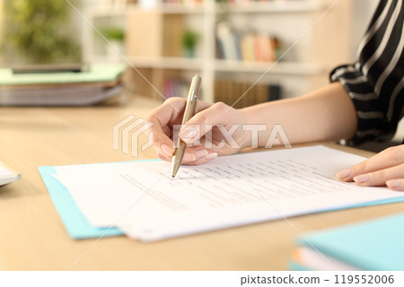 Woman hands filling out form working at home 119552006
