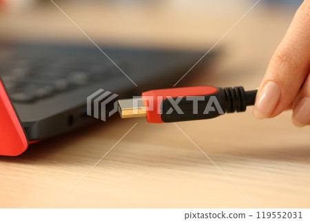 Woman hands plugging hdmi cable on laptop Woman hands plugging hdmi cable on laptop 119552031