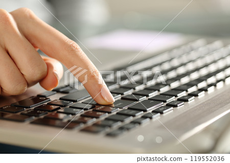 Woman hands pressing enter button on a keyboard 119552036