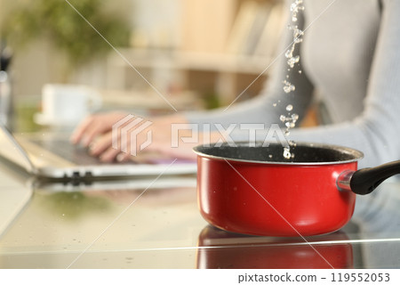 Woman hands typing on laptop suffering water leaks on foreground Woman hands typing on laptop suffering water leaks on foreground 119552053
