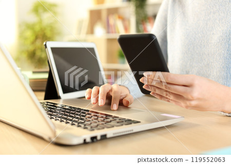 Woman hands using multiple devices at home 119552063