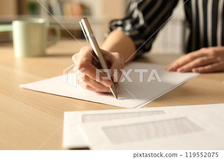 Woman hands writing letter in the night at home 119552075