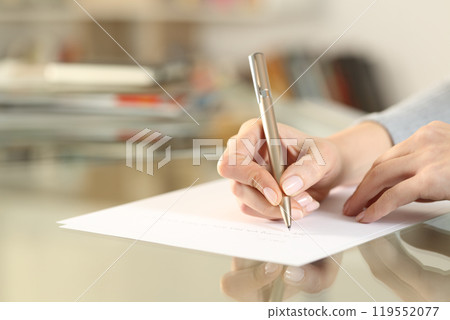 Woman hands writing letter on paper sheet on table 119552077