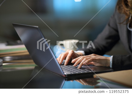 Tele worker hands typing on laptop in the night 119552375
