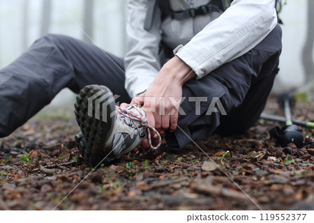 Trekker complaining alone in the mountain with broken ankle 119552377