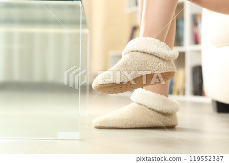Woman feet wearing slippers at home 119552387