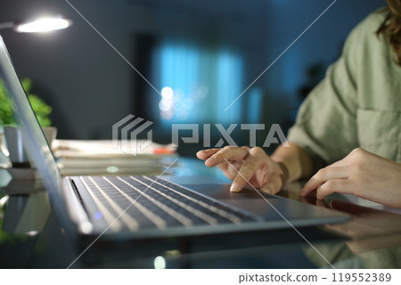 Woman hand browsing on laptop using touchpad in the night Woman hand browsing on laptop using touchpad in the night 119552389