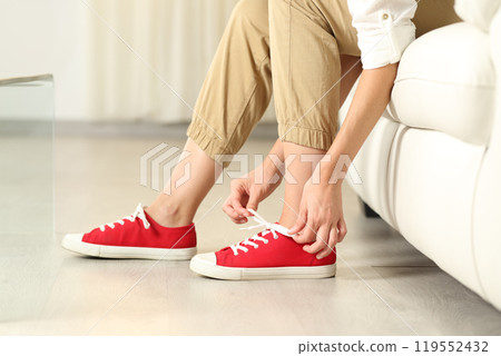 Woman hands tying shoelaces at home Woman hands tying shoelaces at home 119552432