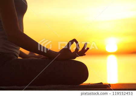 Woman silhouette doing yoga lotus pose at sunset Woman silhouette doing yoga lotus pose at sunset 119552453
