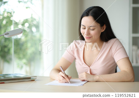 Asian woman filling form in a desk at home 119552621